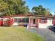Inviting single-story home featuring a well-manicured lawn and charming red accents at 919 Timor Ave, Orlando, FL 32804