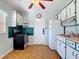 Charming kitchen with floral wallpaper, decorative cabinets, and black appliances at 919 Timor Ave, Orlando, FL 32804
