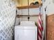 Laundry area including a white washing machine and wooden shelf at 919 Timor Ave, Orlando, FL 32804