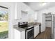 Modern kitchen with updated appliances, granite countertops, and sleek white cabinetry at 925 Valleydale Ave, Deland, FL 32720