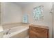 Close up of the tiled soaking tub in bathroom, with large vanity to the side at 10033 Hidden Dunes Ln, Orlando, FL 32832