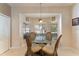 Sunlit breakfast nook with a glass table set in front of large windows offering a pleasant view at 10033 Hidden Dunes Ln, Orlando, FL 32832