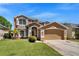 Charming two-story home with a two-car garage, well-maintained lawn, and a welcoming facade at 10033 Hidden Dunes Ln, Orlando, FL 32832