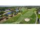 Scenic golf course view with lush green fairways, sand traps, a serene pond, and nearby residential homes, offering a luxurious lifestyle at 10033 Hidden Dunes Ln, Orlando, FL 32832