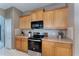 Close-up of kitchen with stainless steel appliances, tile backsplash, and light wood cabinets at 10033 Hidden Dunes Ln, Orlando, FL 32832