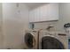 Efficient laundry room featuring a washer, dryer, and overhead storage at 10033 Hidden Dunes Ln, Orlando, FL 32832