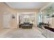 Bright living room featuring large windows, a cozy loveseat, and neutral carpeting at 10033 Hidden Dunes Ln, Orlando, FL 32832