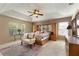 Spacious main bedroom with tray ceiling, ceiling fan, plush carpet and large window at 10033 Hidden Dunes Ln, Orlando, FL 32832