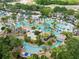 Aerial view showcasing an expansive community pool and lazy river surrounded by lush landscaping at 1004 Castle Pines Ct, Reunion, FL 34747