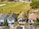 Aerial view of neighborhood homes, showcasing a house near a green golf course and lush landscaping at 1004 Castle Pines Ct, Reunion, FL 34747