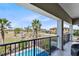 Balcony view of a pool and a blue sky with palm trees at 1004 Castle Pines Ct, Reunion, FL 34747