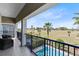 Balcony view of a golf course, pool, and a blue sky with palm trees at 1004 Castle Pines Ct, Reunion, FL 34747