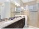Bright bathroom featuring a double vanity with granite countertops and a glass-enclosed shower at 1004 Castle Pines Ct, Reunion, FL 34747