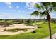 A scenic view of a beautiful golf course with sand traps and green hills under a partly cloudy sky at 1004 Castle Pines Ct, Reunion, FL 34747