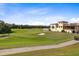 Beautiful golf course scenery, showing the fairway, sand trap, clubhouse, and blue skies with wispy clouds at 1004 Castle Pines Ct, Reunion, FL 34747