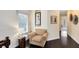 Inviting hallway features hardwood floors, a comfortable chair, and artistic wall decor at 1004 Castle Pines Ct, Reunion, FL 34747