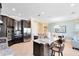 Stylish kitchen with dark cabinetry, granite counters, stainless appliances, and breakfast bar seating at 1004 Castle Pines Ct, Reunion, FL 34747