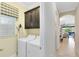 Bright laundry room featuring a washer, dryer, upper cabinets, window with blinds, and an ironing board at 1004 Castle Pines Ct, Reunion, FL 34747