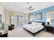 Serene main bedroom featuring a private balcony, stylish furnishings, and soft, natural light at 1004 Castle Pines Ct, Reunion, FL 34747