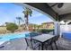Spacious patio with outdoor dining, lounge area, and stunning pool featuring spa and lush landscape views at 1004 Castle Pines Ct, Reunion, FL 34747
