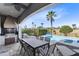 Covered patio with outdoor kitchen, dining, and seating areas overlooking the sparkling pool and spa at 1004 Castle Pines Ct, Reunion, FL 34747