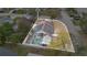 An aerial view of a home with solar panels, a screened-in pool, and a fenced-in backyard at 102 Ethan Ave, Davenport, FL 33897