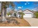 Well maintained single story home featuring a two-car garage and mature tree in the front yard at 102 Ethan Ave, Davenport, FL 33897