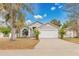 Charming single Gathering home featuring a two-car garage and nicely landscaped front yard under a sunny blue sky at 102 Ethan Ave, Davenport, FL 33897