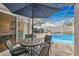 Inviting outdoor patio with dining set and views of the sparkling pool and spa for relaxation at 102 Ethan Ave, Davenport, FL 33897
