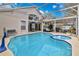 Inviting pool and spa area with seating, covered patio, and lush landscaping for ultimate relaxation and fun at 102 Ethan Ave, Davenport, FL 33897