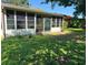 View of the back of the home with a screened in patio and large windows at 10223 Marco Polo Dr, Orlando, FL 32821