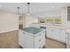 Bright kitchen features an island, white cabinets, recessed lights, and a large window overlooking a natural landscape at 1035 W Minnehaha Ave, Clermont, FL 34711