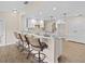Open-concept living room featuring hardwood floors, bar seating, and a view of the kitchen at 1035 W Minnehaha Ave, Clermont, FL 34711