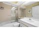 Well-lit bathroom featuring a shower-tub combo with glass doors and a single sink vanity at 1055 Kensington Park Dr # 609, Altamonte Springs, FL 32714