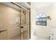 Bathroom featuring a glass enclosed shower with a gold frame and an arched window at 1055 Kensington Park Dr # 609, Altamonte Springs, FL 32714