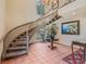 Elegant foyer with a curved staircase, chandelier, floral arrangement, and warm tile flooring at 1055 Kensington Park Dr # 609, Altamonte Springs, FL 32714