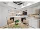 Bright kitchen with white cabinets and black appliances plus a dining table for casual meals at 1055 Kensington Park Dr # 609, Altamonte Springs, FL 32714