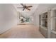 An open living room features a mirrored bar, custom shelving, neutral carpet, and a ceiling fan at 1055 Kensington Park Dr # 609, Altamonte Springs, FL 32714