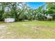 Spacious backyard featuring a shed, animal pens, and mature trees for added privacy at 1095 Grand Ave, Orange City, FL 32763