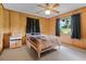 This bedroom has wood paneling, neutral carpet and a bright window view at 1095 Grand Ave, Orange City, FL 32763