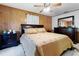 Comfortable bedroom features wood paneling, a ceiling fan, and coordinating furniture at 1095 Grand Ave, Orange City, FL 32763
