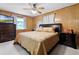 Comfortable bedroom featuring wood paneled walls and a ceiling fan at 1095 Grand Ave, Orange City, FL 32763