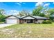 Charming brick home with an attached garage and inviting front porch under a sunny, blue sky at 1095 Grand Ave, Orange City, FL 32763