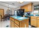 Charming kitchen with wooden cabinetry, an island, and black appliances at 1095 Grand Ave, Orange City, FL 32763