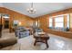 Cozy living room with wood paneled walls, plush seating, and a bay window with a built-in bench at 1095 Grand Ave, Orange City, FL 32763