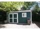 Backyard shed with double doors, window, and trash bin at 115 W King St, Orlando, FL 32804