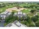 An aerial view of the condo building surrounded by a lush golf course, trees, and walking paths at 1360 Centre Court Ridge Dr # 201, Reunion, FL 34747