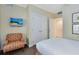 Neutral bedroom with TV, chair and views to the closet, entry, and Primary bath provides ample living space at 1360 Centre Court Ridge Dr # 201, Reunion, FL 34747
