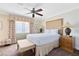 Bright bedroom featuring a plush bed, ceiling fan, and soft, beach-themed decor and a window view at 1360 Centre Court Ridge Dr # 201, Reunion, FL 34747