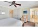Comfortable bedroom featuring a ceiling fan, TV, chair, and view to a bathroom, closet, and entry at 1360 Centre Court Ridge Dr # 201, Reunion, FL 34747